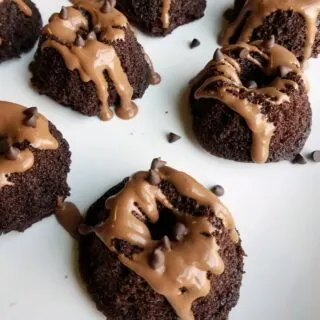 close up of mini chocolate bundt cakes with chocolate drizzle and mini chips.