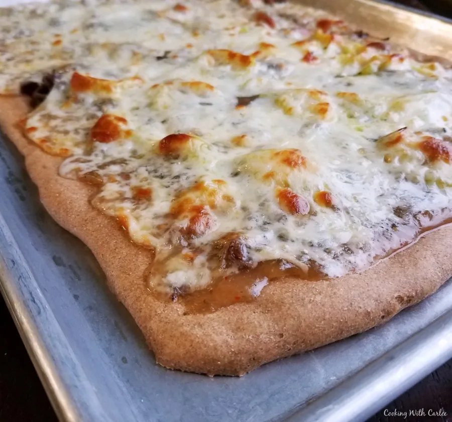 corner of freshly baked pizza on sheet pan.