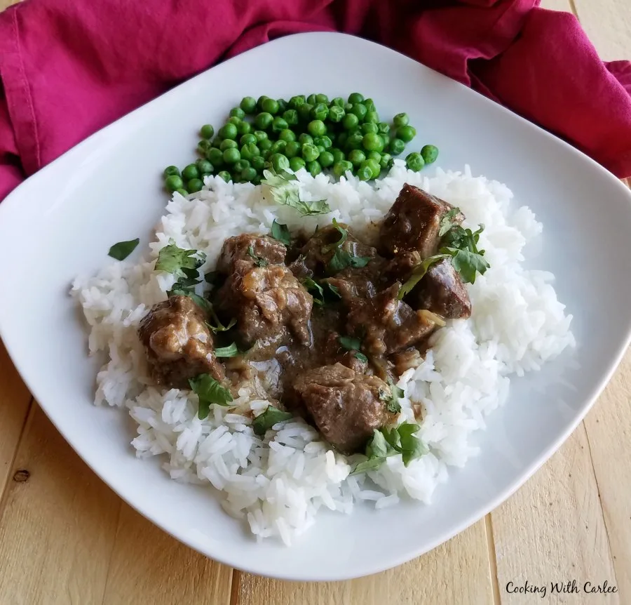 dinner plate with lamb curry and green peas.