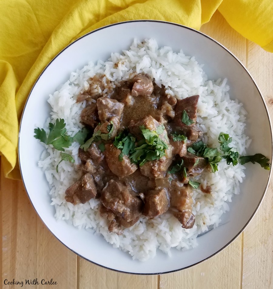 lamb curry served over rice with a sprinkling of fresh parsley