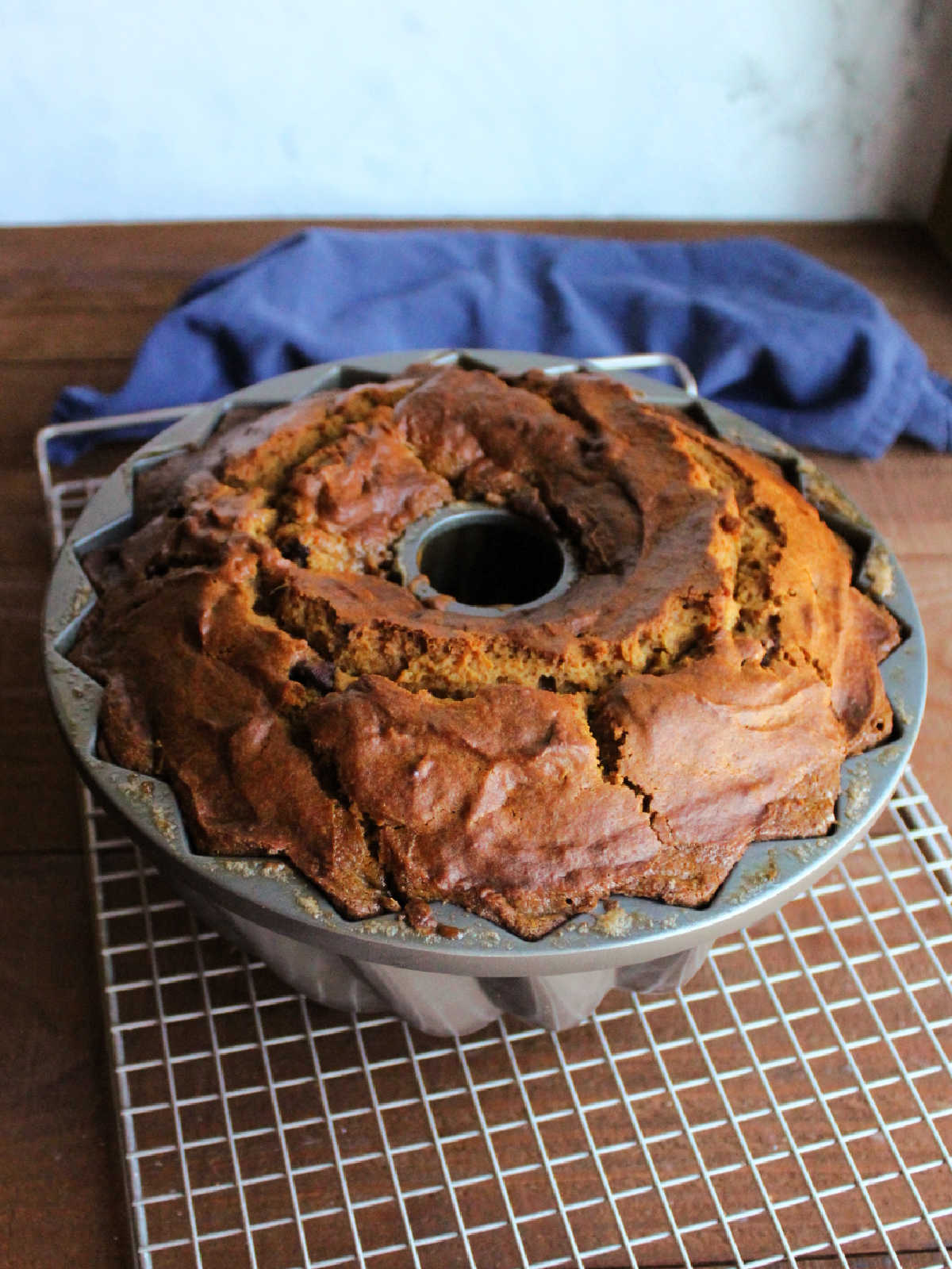 Freshly baked pumpkin bundt cake cooling on wire rack before being tipped out of the pan.