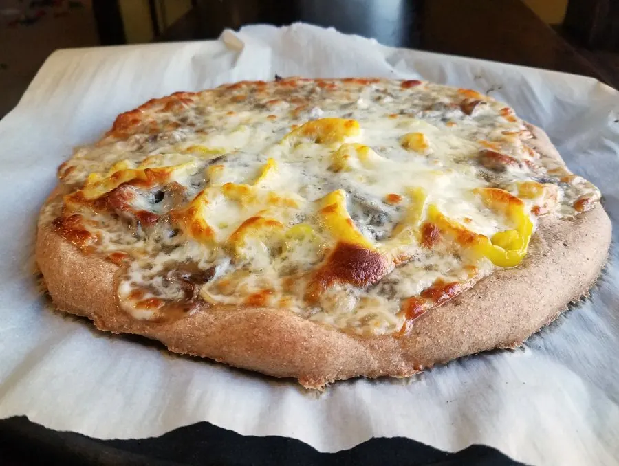 round Italian beef pizza with golden cheese and pepper rings.