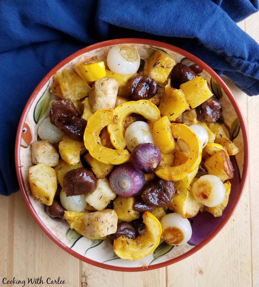 Bowl filled with roasted vegetables glazed with maple syrup and herbs.