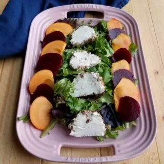 platter filled with salad topped with beets, persimmons and cheese.