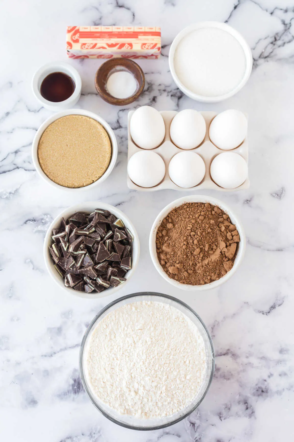 Ingredients including flour, sugar, brown sugar, cocoa powder, eggs, butter, vanilla, baking soda, and chopped Andes mints.