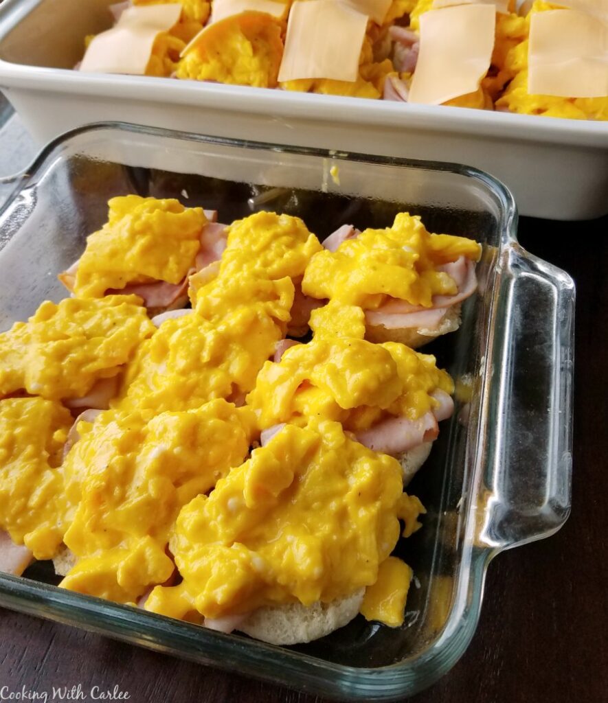 building sliders in pan with laers of rolls, ham and scrambled eggs.