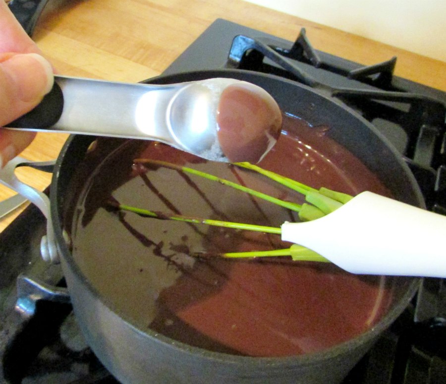 Thickened chocolate pudding mixture coating the back of a measuring spoon.
