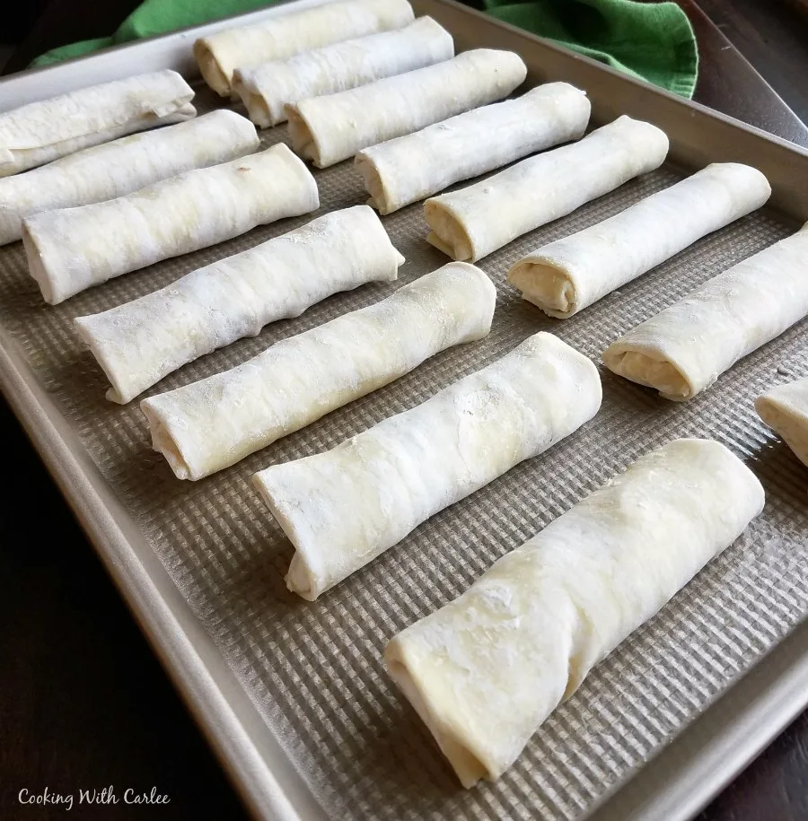 Tray filled with homemade egg rolls ready to be baked.