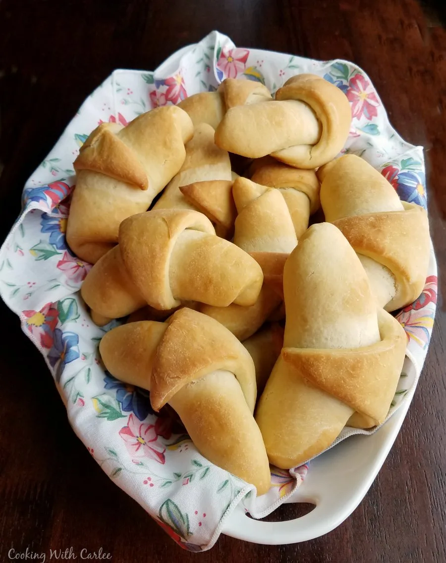 serving dish filled with golden brown sourdough crescent rolls ready to eat.