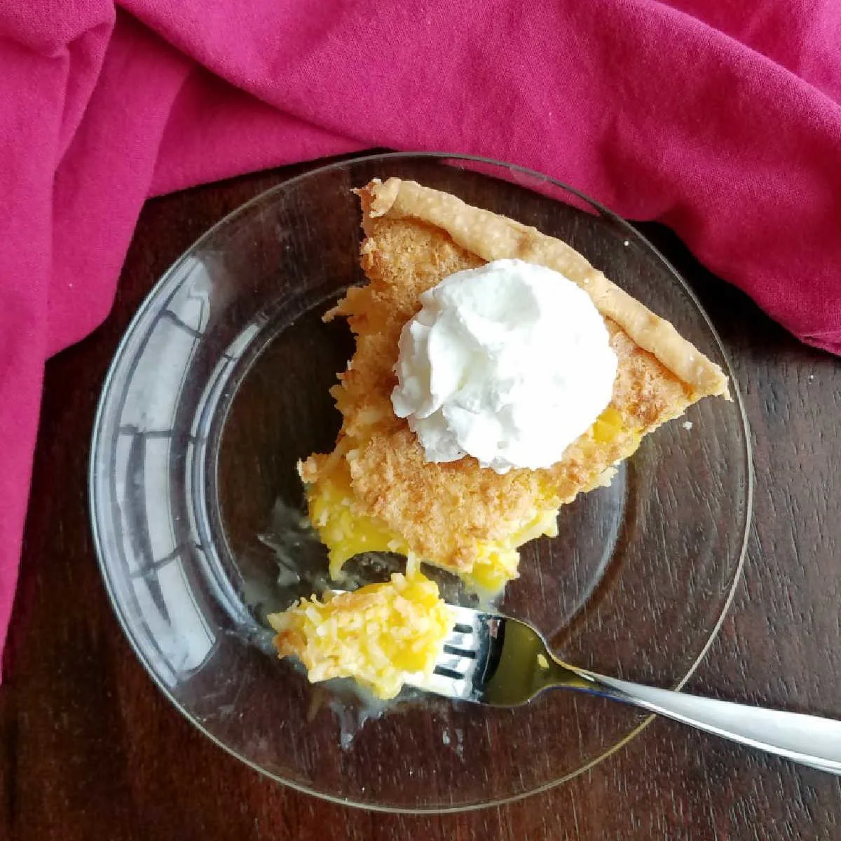 slice of coconut and pineapple pie with whipped cream on top.