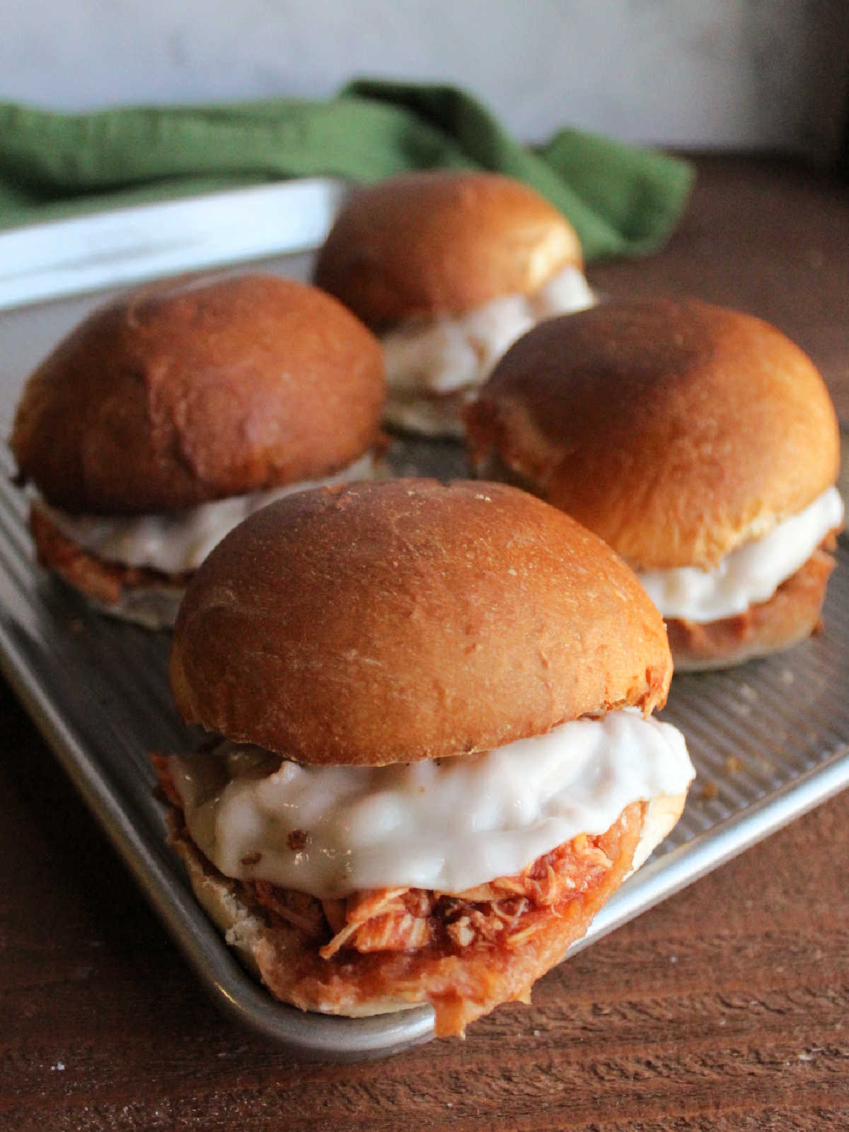 Shredded chicken parmesan sandwiches with melted cheese and toasted garlic bread buns. 