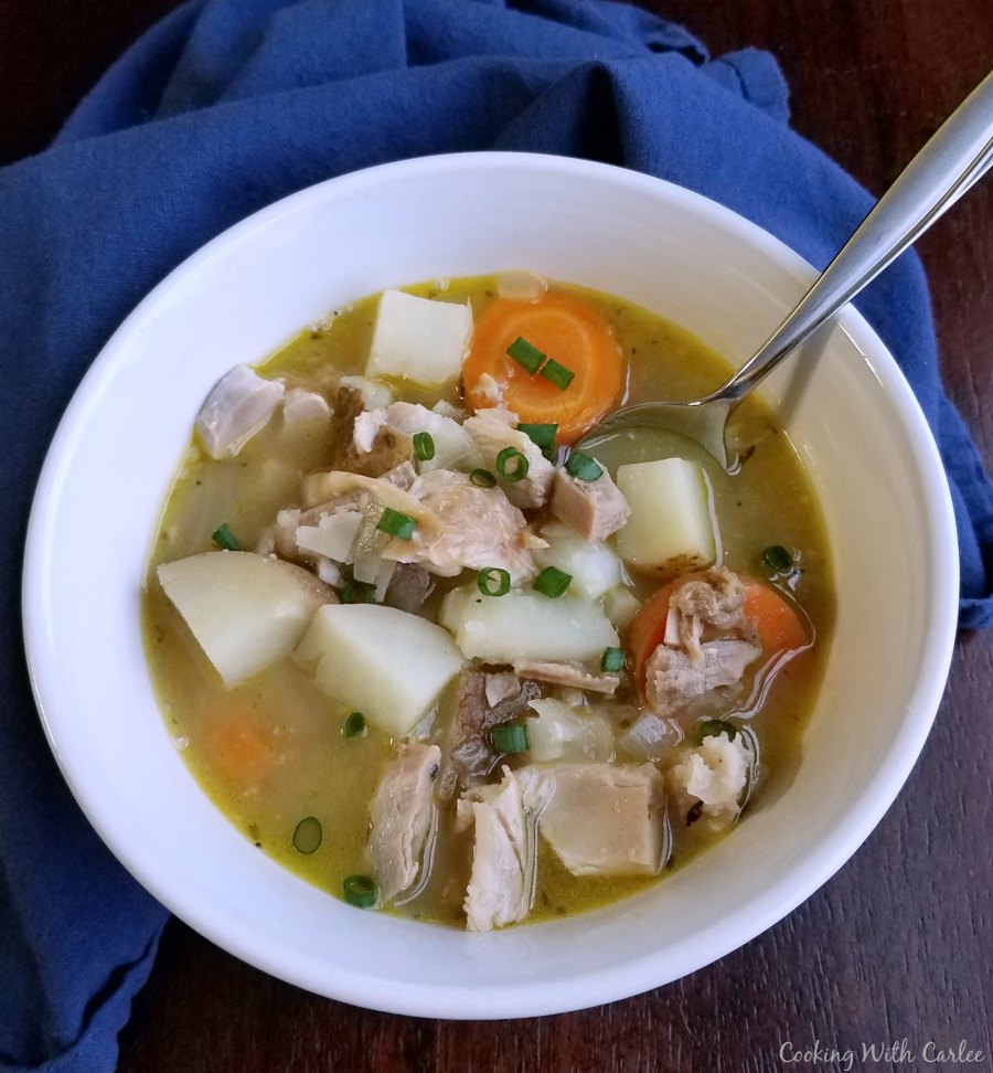 bowl of chunky chicken stew with potatoes, carrots and leftover chicken.
