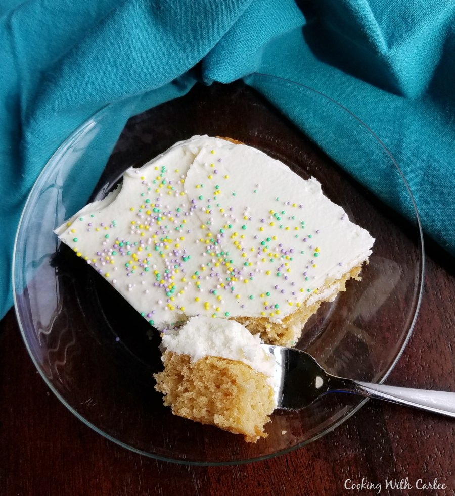 fork taking bite of peanut butter sheet cake with fluffy white chocolate frosting.