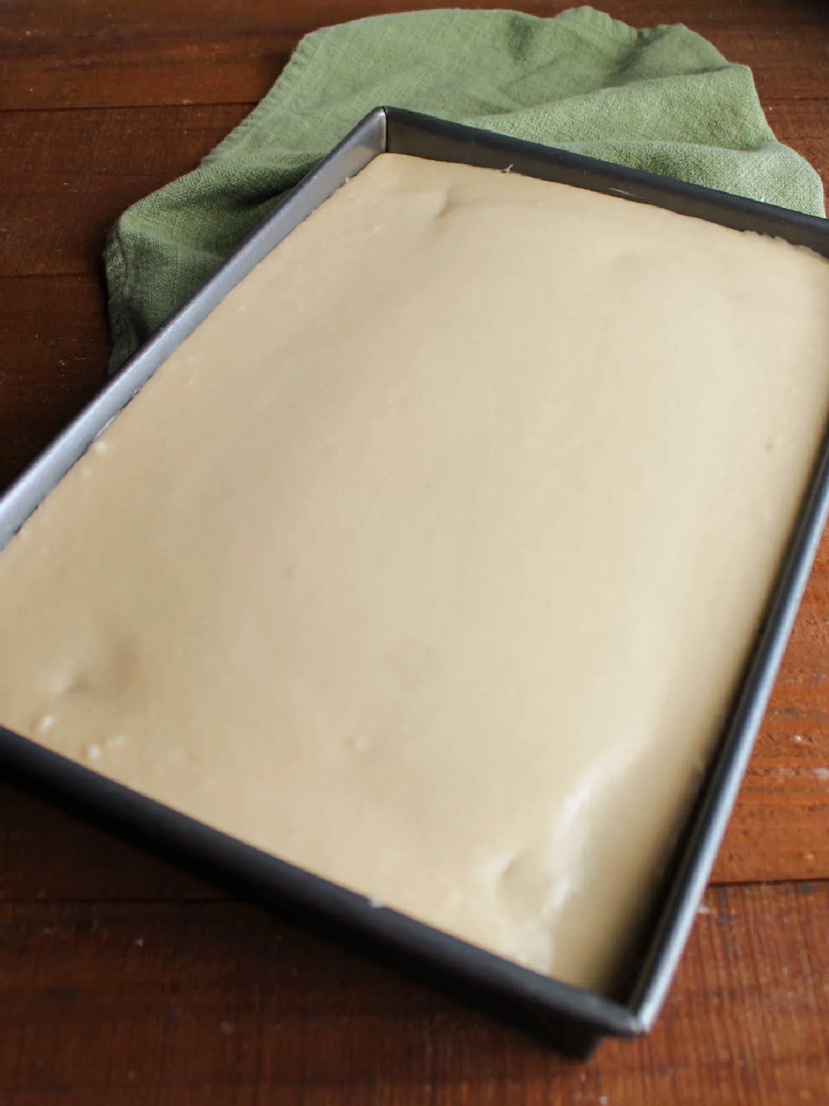 Smooth butterscotch icing spread over cake in 9x13-inch pan.