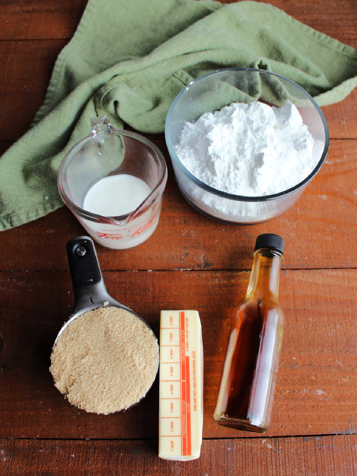 Icing ingredients including butter, brown sugar, milk, vanilla, and powdered sugar ready to get made into penuche icing.