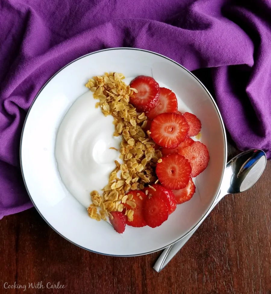 bowl of yogurt with strawberry slices and homemade granola.