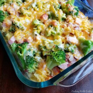 Casserole dish filled with pasta, ham, broccoli and melted cheese baked together into a full meal.
