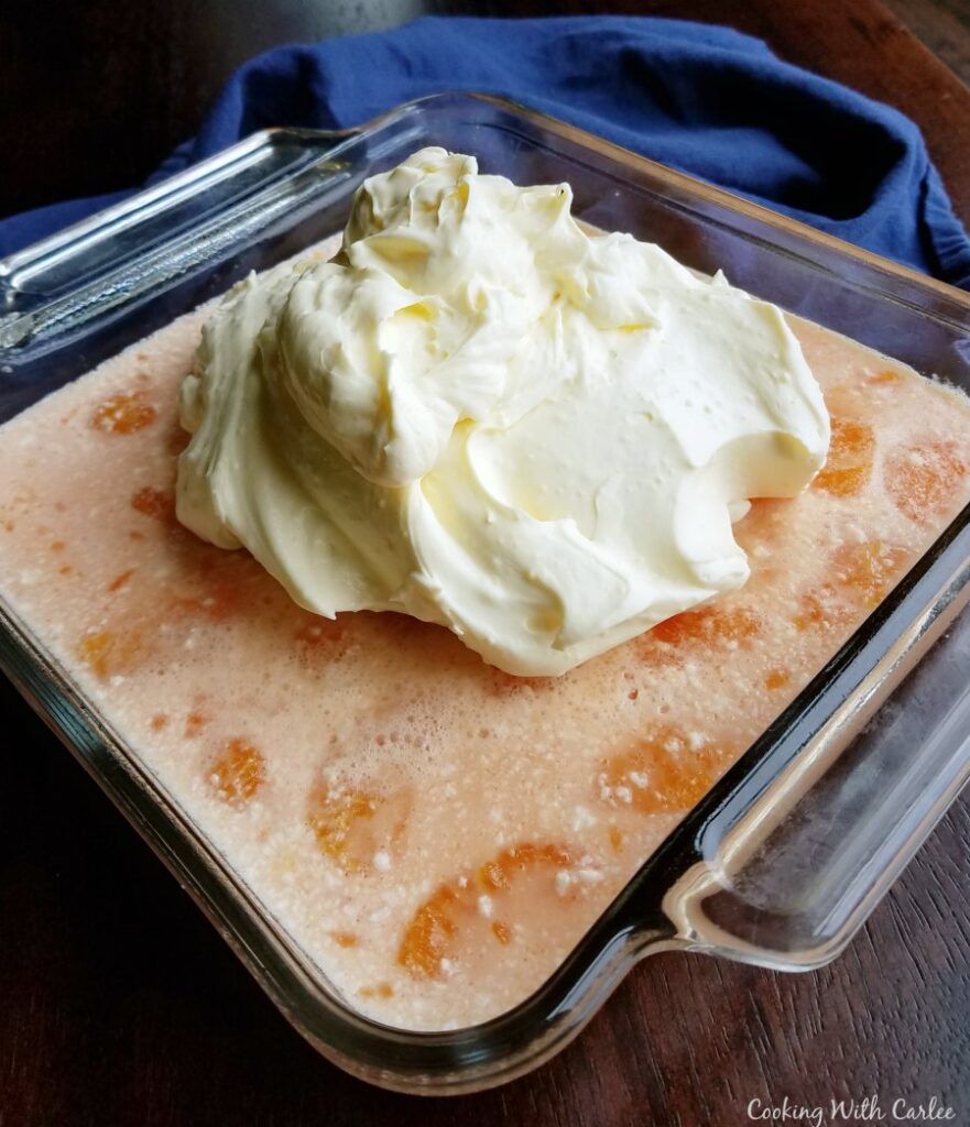 creamy jello and orange layer set with cream layer plopped on top.