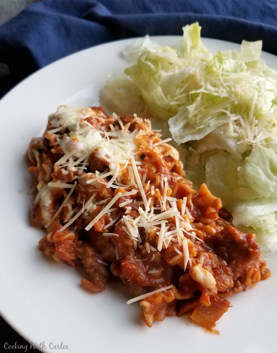 serving of skillet lasagna with shredded parmesan and salad on a plate