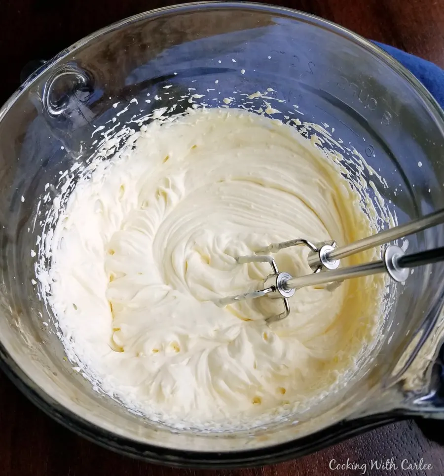 creamy vanilla pudding and whipped cream topping layer in mixing bowl with beaters.