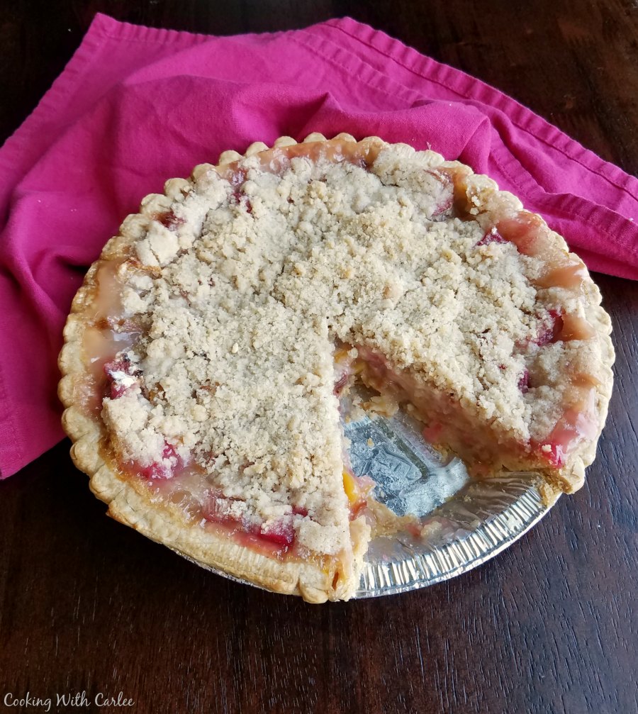 peach rhubarb pie with one slice missing