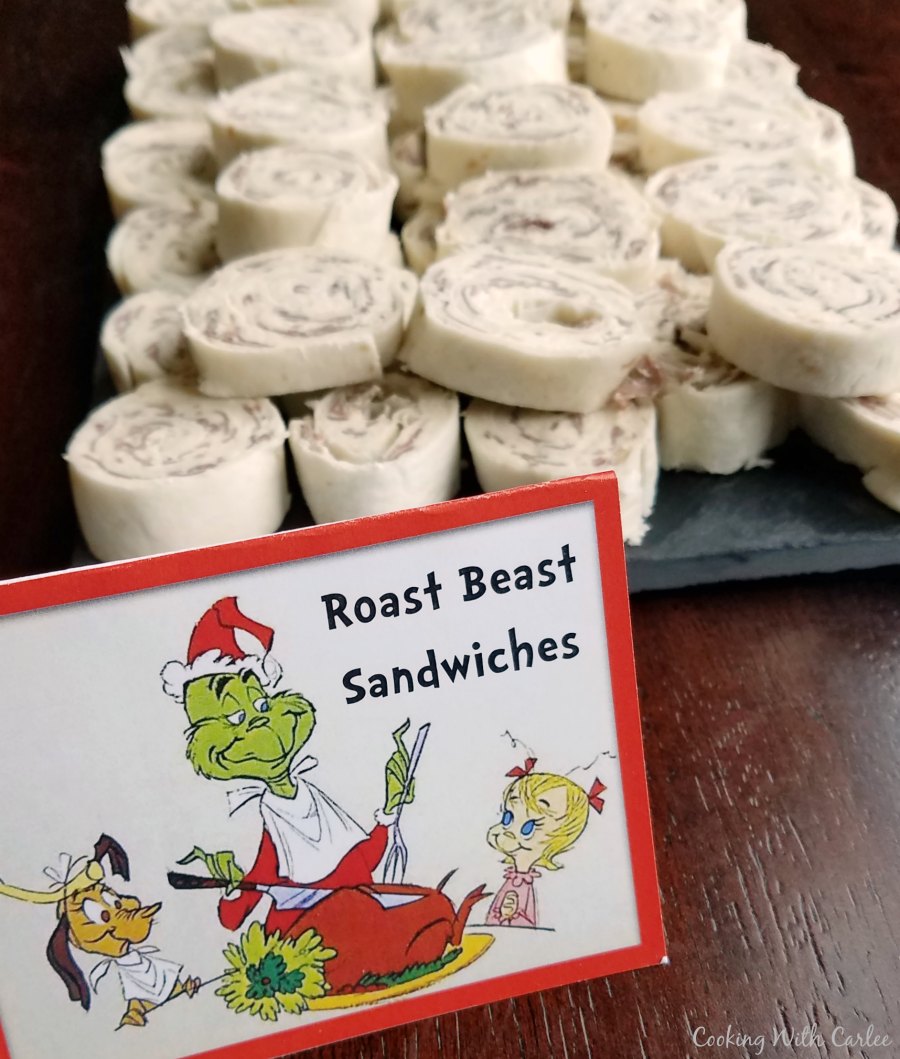 Roast beast rollups on platter next to Grinch sign.