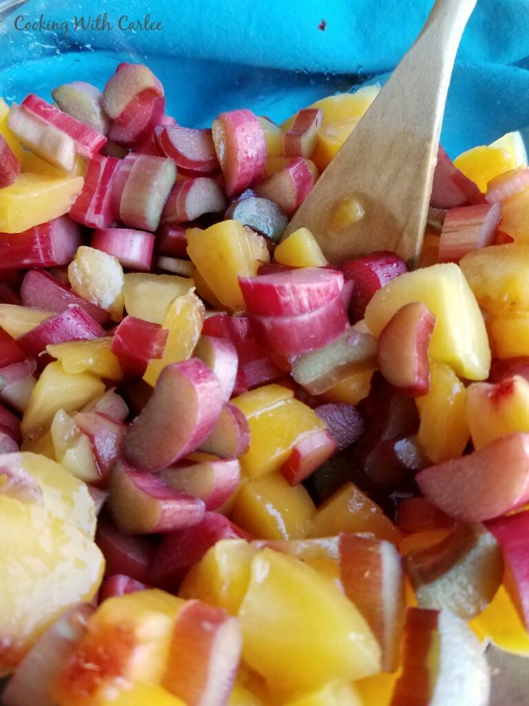 chopped peaches and rhubarb getting made into filling for pie