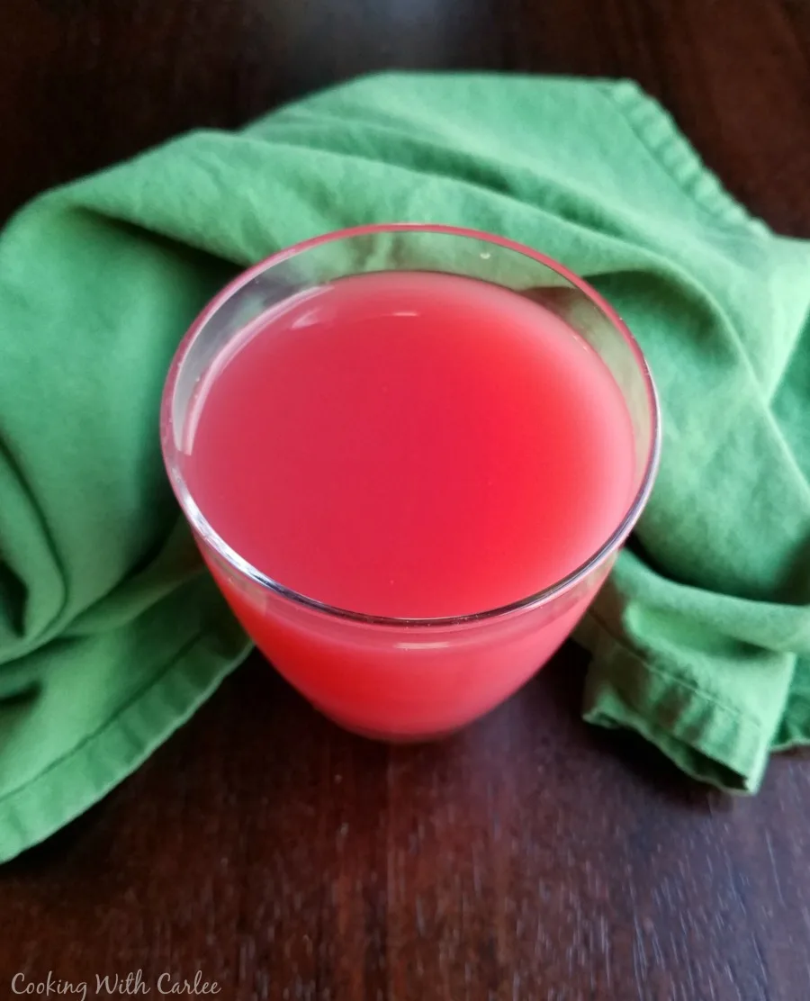 looking down at glass of pink sherbet punch.