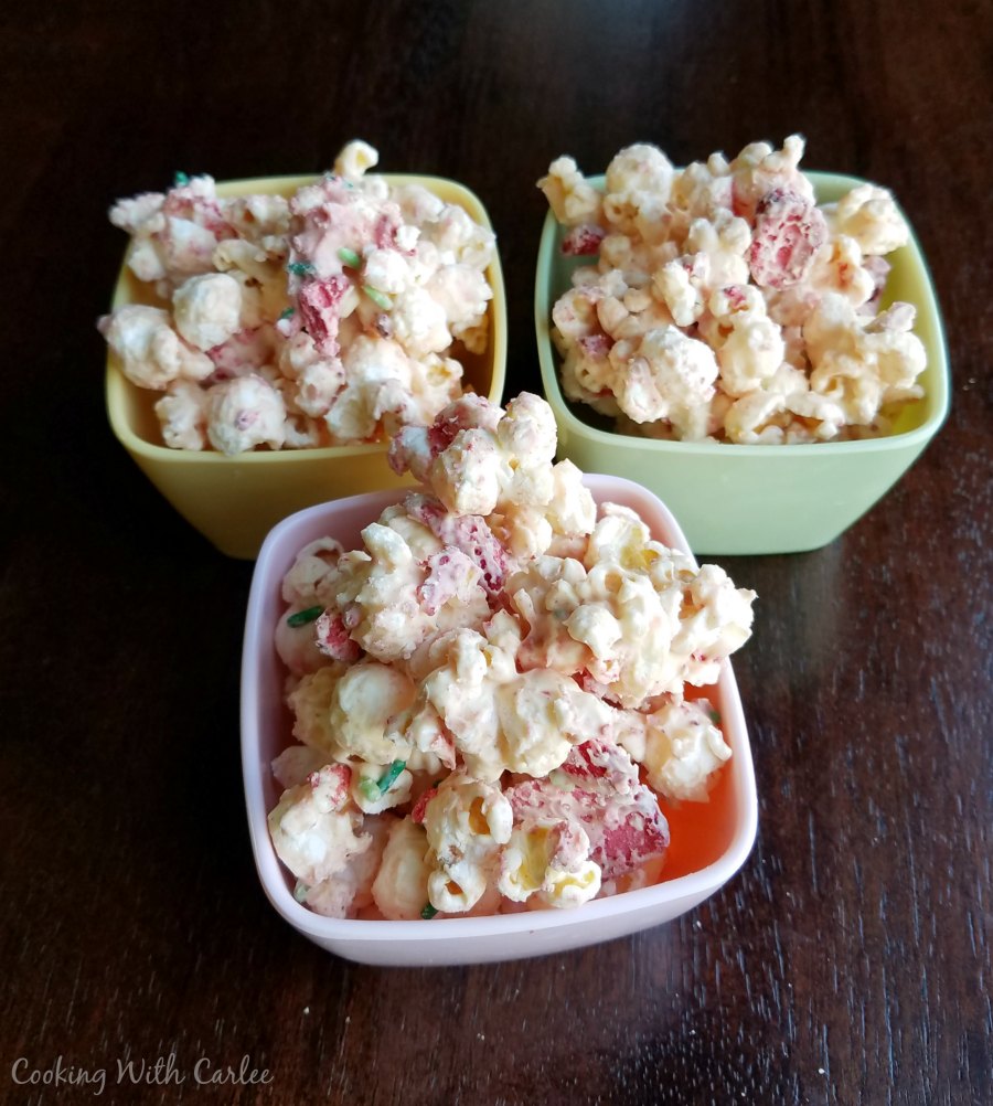 3 small bowls of white chocolate and strawberry coated popcorn