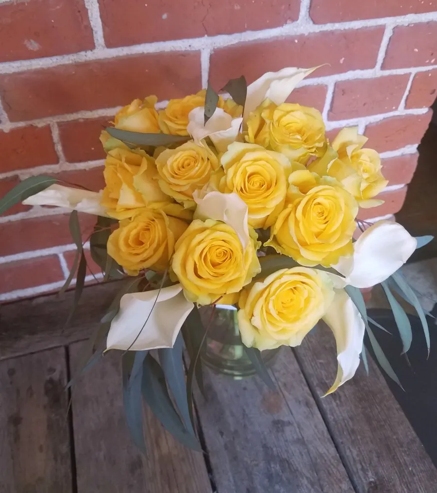 Boquet of yellow roses and white calla lillies.