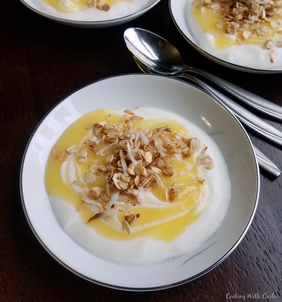 bowl of yogurt topped with lemon curd and coconut granola.