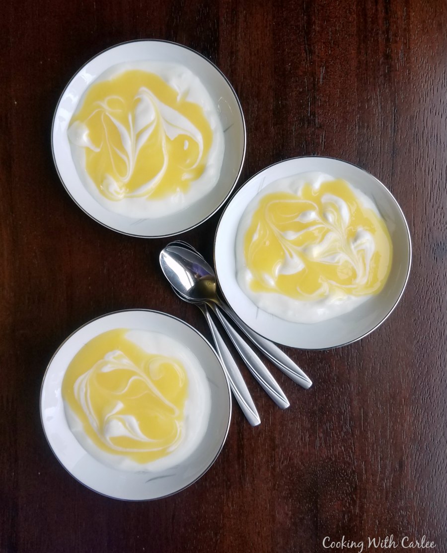 small bowls of yogurt with lemon curd swirled over the top