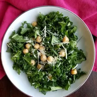 bowl of simple kale salad with lemon, chickpeas and Parmesan cheese.