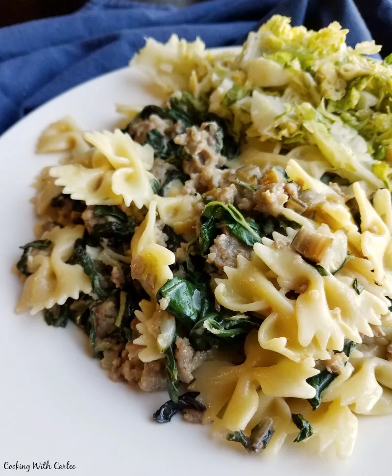 plate of creamy pasta with Italian sausage and wilted chard, ready to eat.