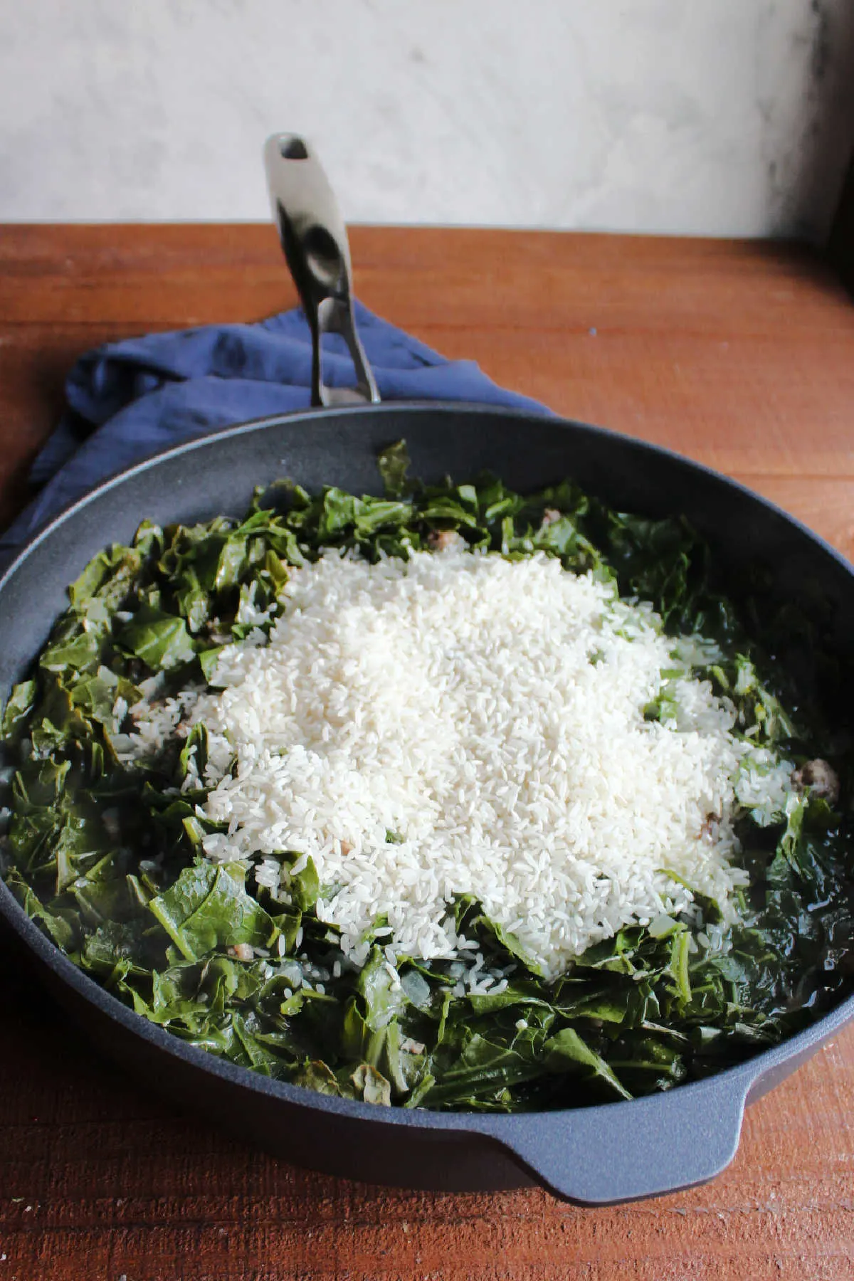 Rice on top of partially cooked collard greens that have now shrunk and easily fit inside the pan.