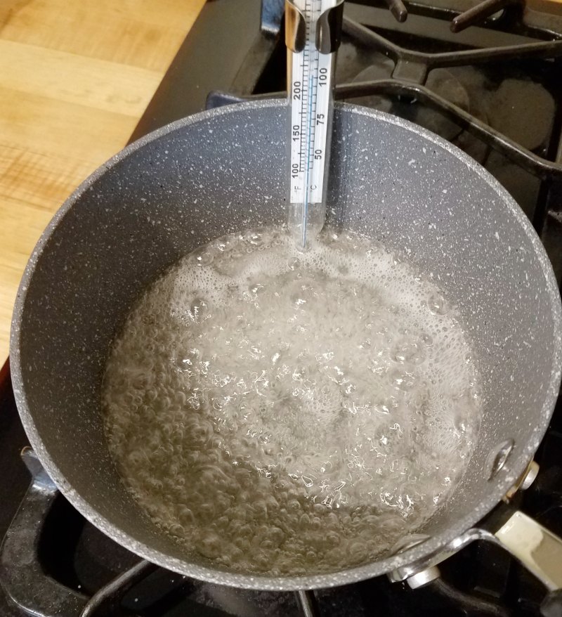sugar syrup boiling in saucepan.