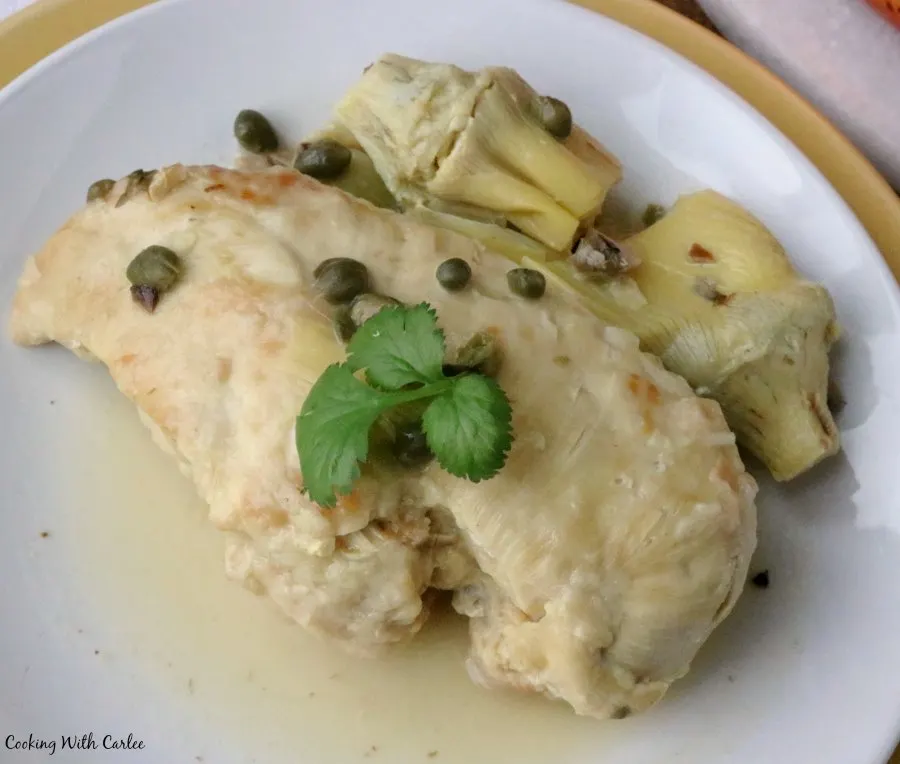 close up of large chicken breast with lemon piccata sauce.