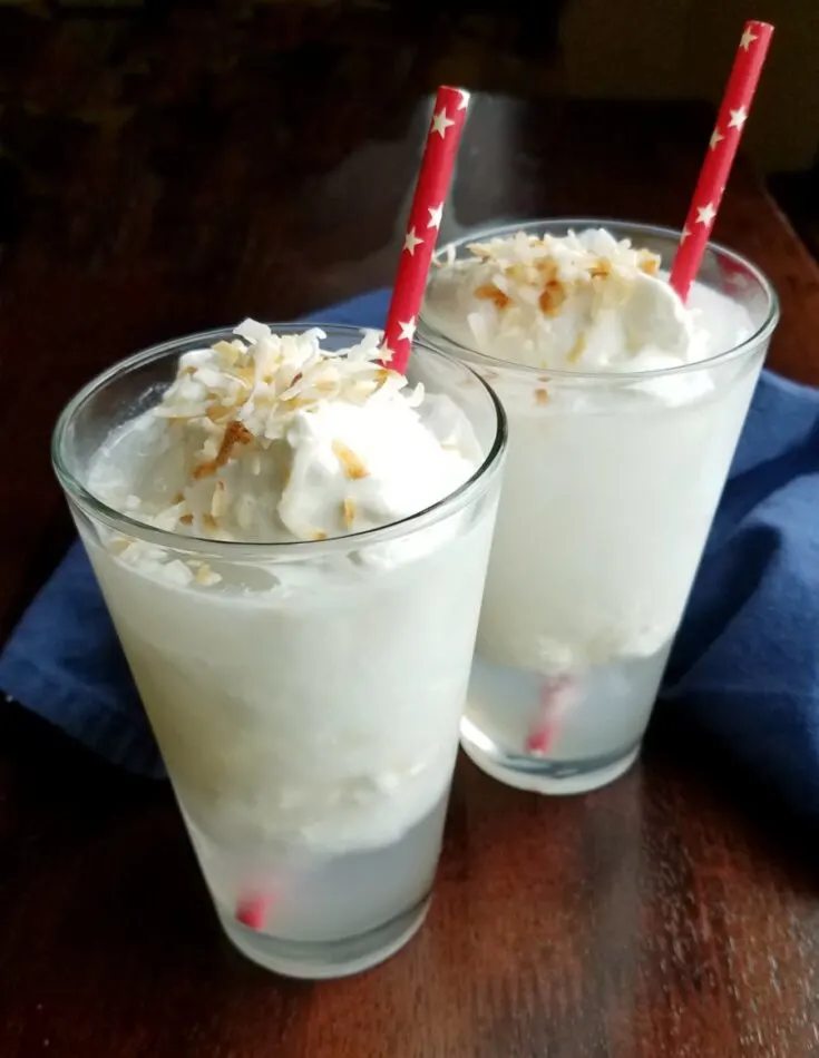 two glasses of creamy Italian sodas with paper straws and toasted coconut.