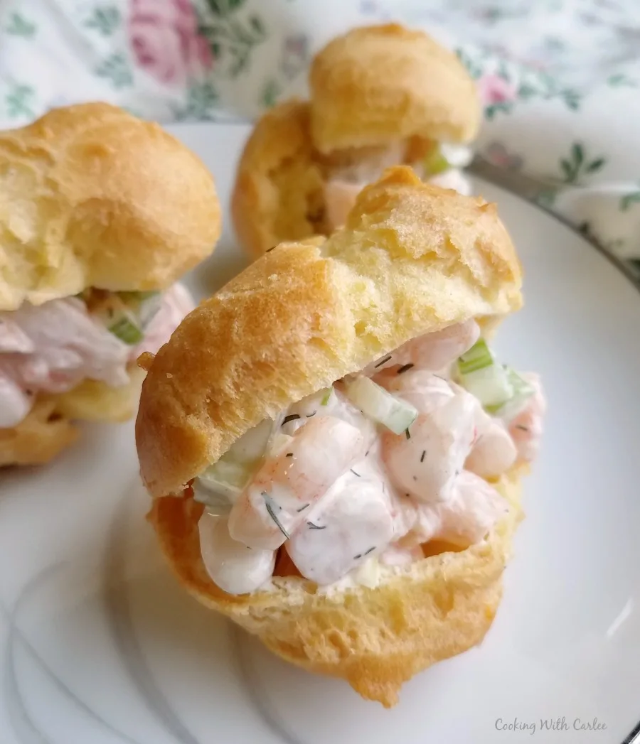 Shrimp salad with creamy dressings and bits of celery inside a golden brown choux pastry profiterole.
