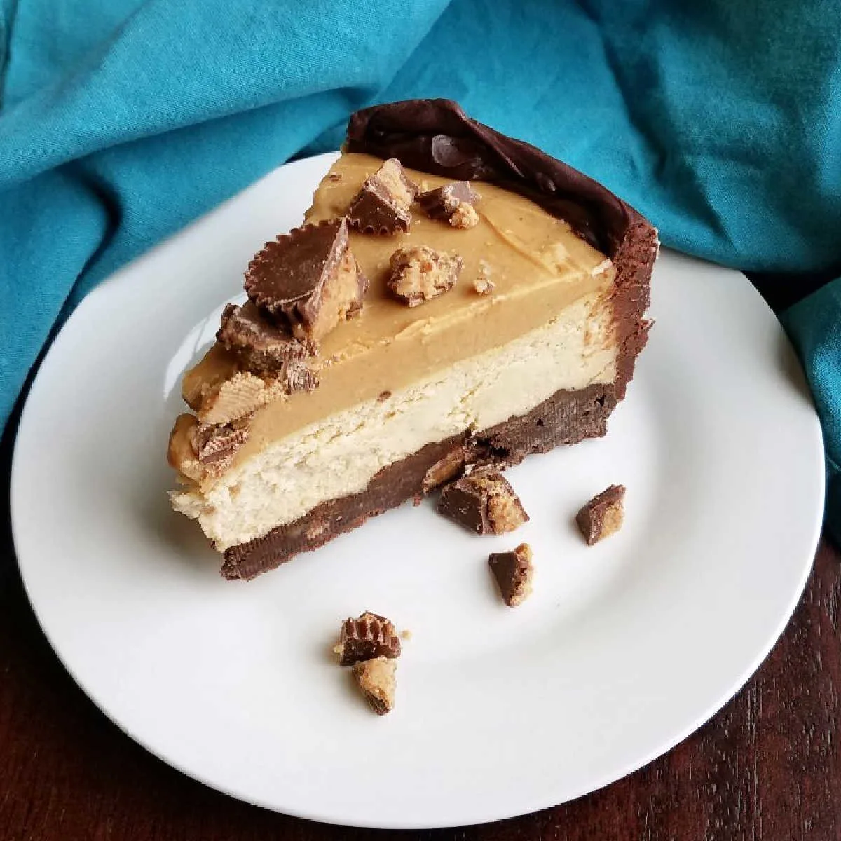 Layers of chocolate crust, creamy peanut butter cheesecake and rich peanut butter topping with chopped peanut butter cups on top.