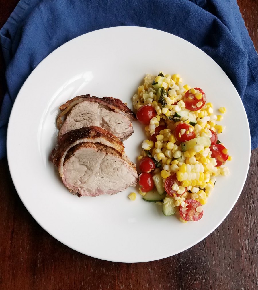 bacon wrapped pork loin served with summer corn salad