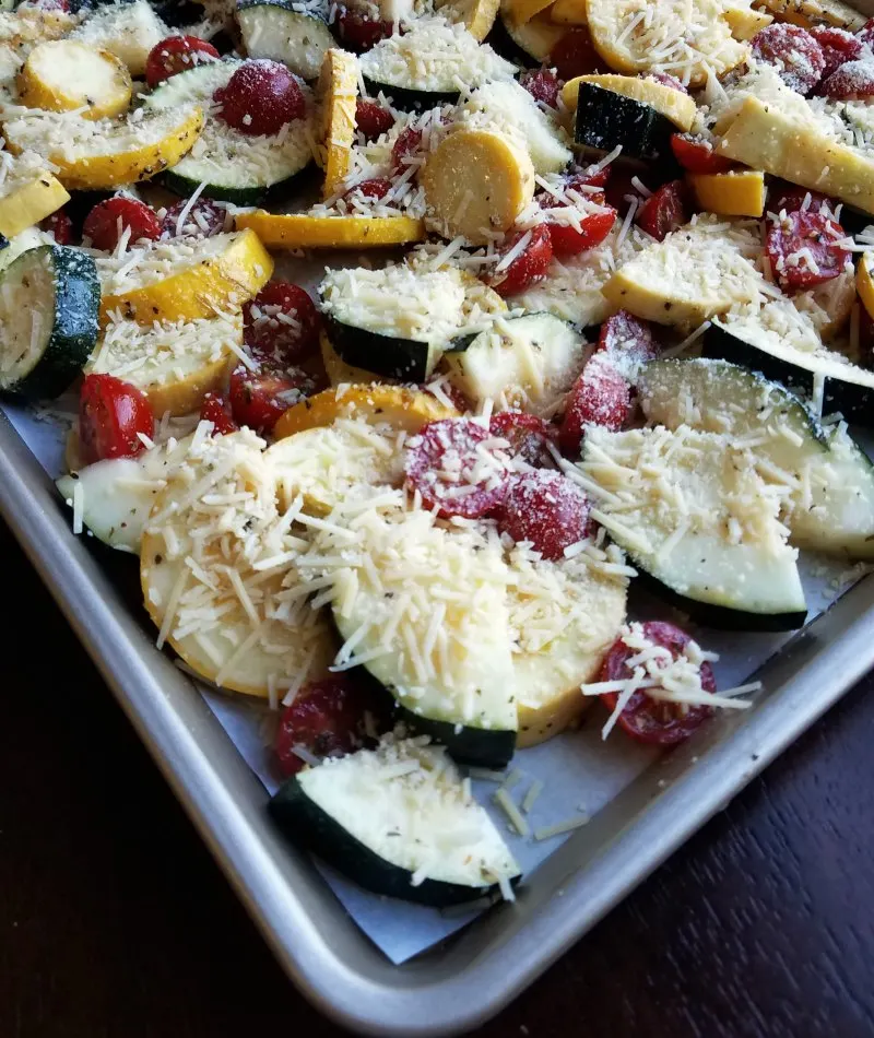 marinated zucchini and tomatoes covered with grated Parmesan ready to roast.