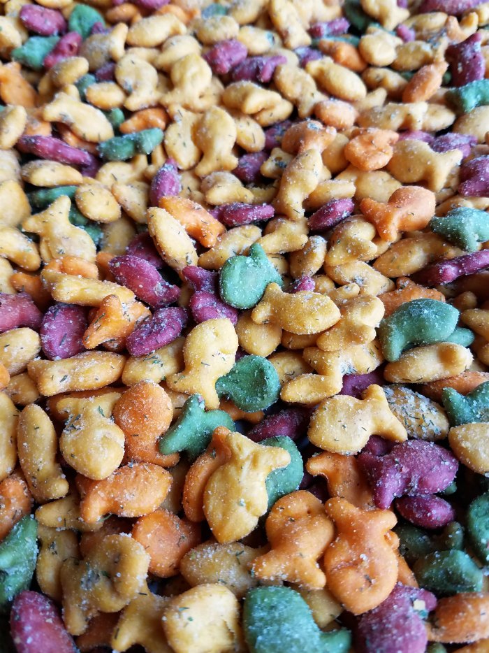 Pile of colorful goldfish crackers baked in a dill and ranch spice mix.