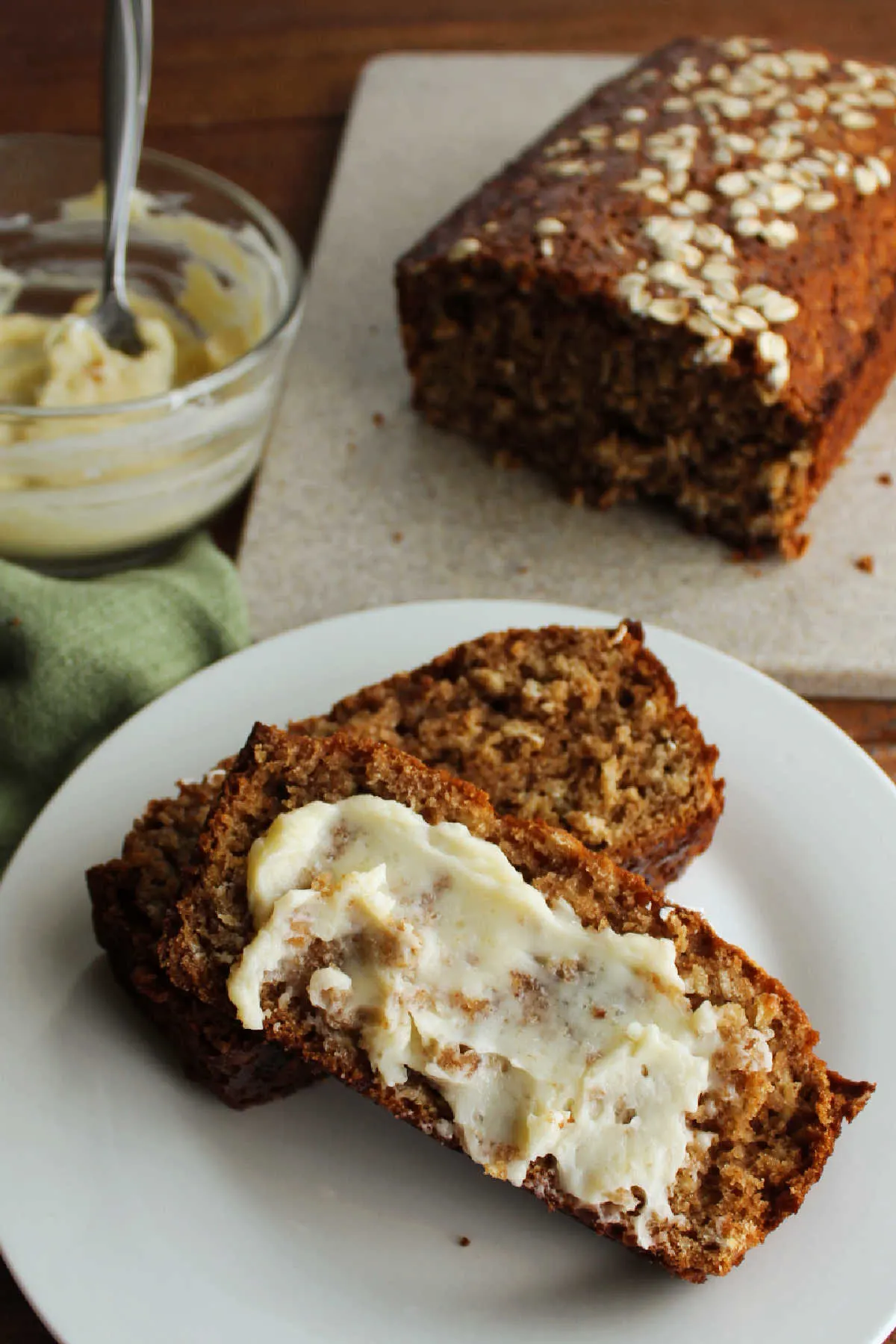 Slice of applesauce quick bread topped with vanilla honey butter, ready to eat.