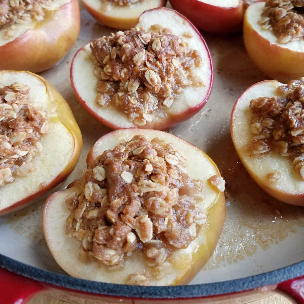 Pan of baked apple halves with brown sugar and oatmeal filling.