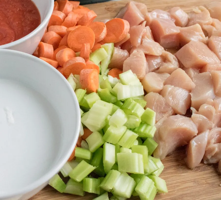 cutting board with diced celery, carrots and chicken.