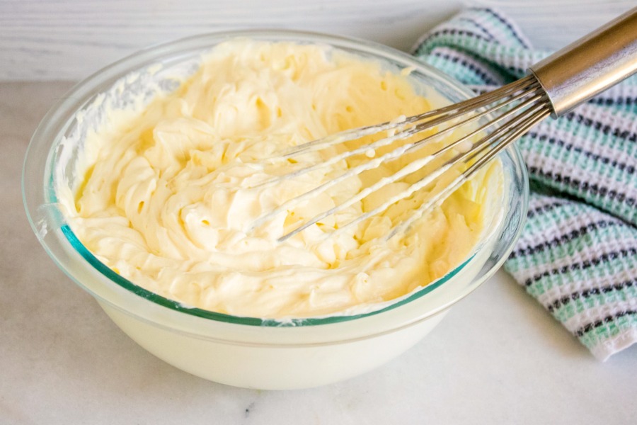 whisk in a bowl of whipped cream and sweetened condensed milk mixed together.