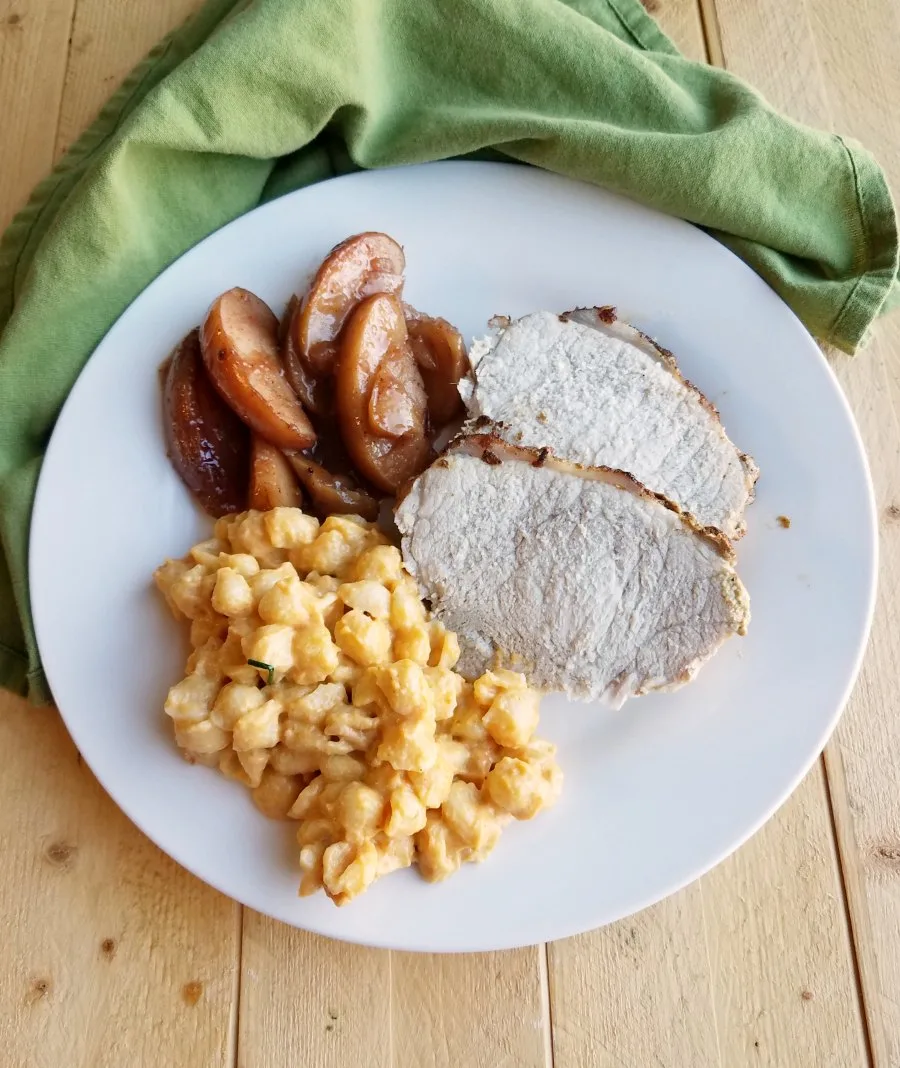 dinner plate with pork loin, mac and cheese and cinnamon apples