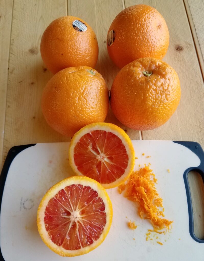 inside of blood orange halves with additional oranges in background.