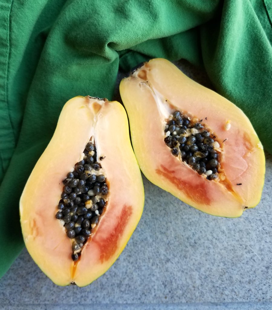 strawberry papaya cut in half with black seeds in center.